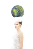 Dekle z visoko pričesko v obliki modro zelene krogle, ki predstavlja Zemljo